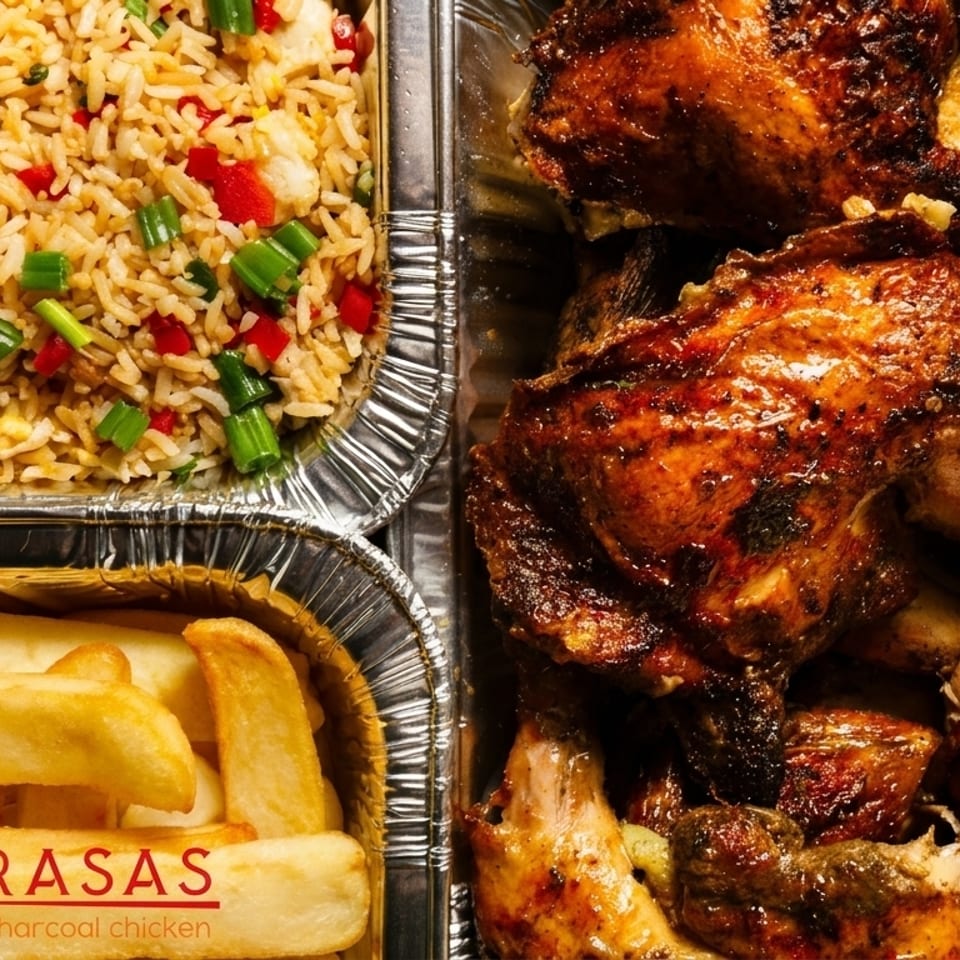 Las Brasas charcoal chicken, fried rice, and french fries in foil containers.